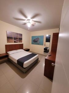 1 dormitorio con 1 cama y ventilador de techo en Conde Hotel Piura, en Piura