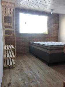 een slaapkamer met een bed, een raam en een ladder bij Hostel Descanso dos Amigos Reserve Quarto Completo in Prado