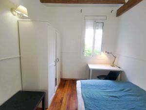Schlafzimmer mit einem Bett, einem Schreibtisch und einem Fenster in der Unterkunft VL51 in Barcelona