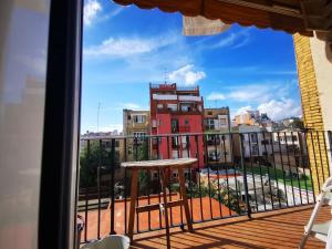 un balcón con una mesa y un edificio rojo en VL51, en Barcelona