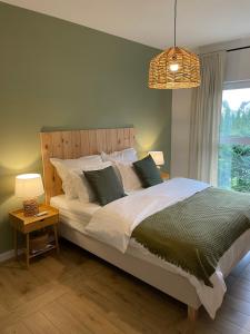 a bedroom with a large bed and a window at Apartament FOREST - HOME APART in Ostróda