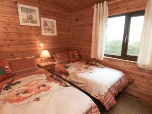 een slaapkamer met 2 bedden in een blokhut bij Sycamore Lodge in Saltburn-by-the-Sea