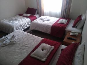 um quarto de hotel com três camas e uma janela em Hotel Casa La Riviera em Bogotá