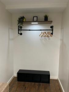 eine schwarze Bank in einem Zimmer mit einer weißen Wand in der Unterkunft Luxury 1 or 2 bedroom Apartment Birmingham City Centre in Birmingham