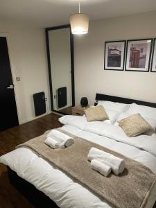 a large white bed with towels on top of it at Luxury 1 or 2 bedroom Apartment Birmingham City Centre in Birmingham