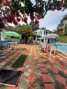 Finca Villa Luz في Nimaima: فناء به طاولات وكراسي بجانب مسبح