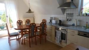 a kitchen with a wooden table and chairs and a table and a stove at Eifelidylle am MoselMaareRadweg in Wittlich