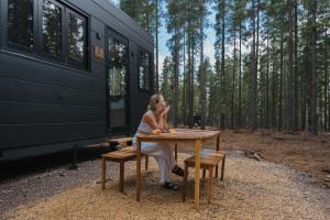 a woman sitting at a table in front of a rv at CABN Kuitpo Forest in Kuitpo
