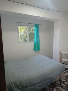 a bed in a white room with a window at Mi cielo in Santa María
