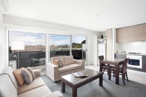 a living room with a couch and a table at Adara St Kilda in Melbourne