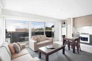 a living room with a couch and a table at St Kilda Central Apartments in Melbourne