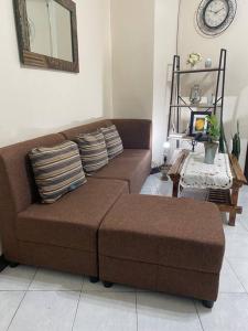 a living room with a brown couch and a table at Baguio Breeze Condo2 in Baguio