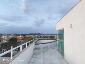 a balcony with a swimming pool on top of a building at Apto Praia Inteiro Florestas das Gaivotas in Rio das Ostras