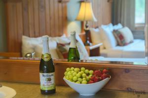 two bottles of wine and a bowl of fruit on a table at Hotel Rio Vista in Winthrop