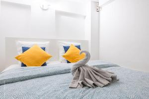 a swan towel sitting on a bed with yellow pillows at L'Atelier Loft-Invalides Tour Eiffel- 6 pers-2 Chambres - Cosy in Paris