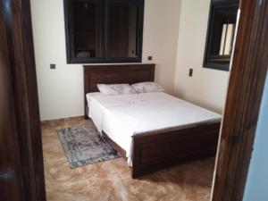 a small bedroom with a bed and a mirror at Appartement familial 1 in Oualidia