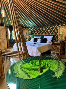 a room with a bed and a table in a room at Solar do Oriente - Glamping mountain experience in São Joaquim