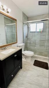 Un baño con inodoro, lavabo y ducha. en Miramar Private Luxury Room/Bath/WiFi, en Miramar