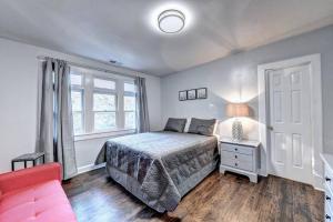 a bedroom with a bed and a red couch at Centrally Located Lux Home - Sleeps 14 in Atlanta
