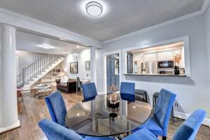une salle à manger avec une table en verre et des chaises bleues dans l'établissement Centrally Located Lux Home - Sleeps 14, à Atlanta