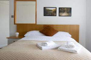 a bedroom with two towels on a bed at One-Bedroom flat in Cheam Village in Cheam