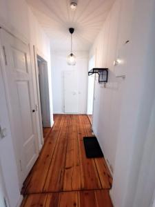 an empty hallway with a wooden floor and a white door at Schöne Unterkunft in Prenzlauer-Berg in Berlin