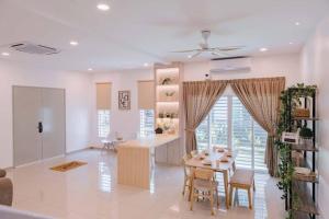 une cuisine et une salle à manger avec une table et des chaises dans l'établissement Pillow Cottage Semi-D Home Stay Town Malacca (18pax), à Malacca