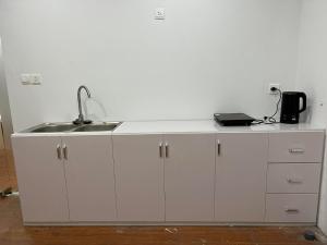 a white kitchen with a sink and a counter at Ký túc xá Vincom Trần Duy Hưng - Hai khu nam nữ riêng biệt in Hanoi