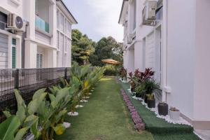 une cour intérieure d'un bâtiment avec des plantes et de l'herbe dans l'établissement Pillow Cottage Semi-D Home Stay Town Malacca (18pax), à Malacca