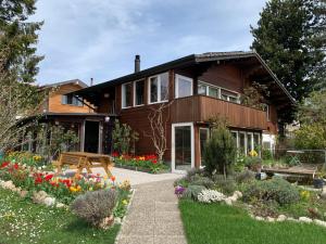 a wooden house with flowers in front of it at Jolie chambre dans chalet in Le Vaud