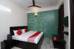 um quarto com uma cama com almofadas vermelhas em Collection O Delta Square em Gurgaon