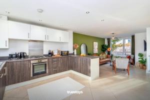 a kitchen with wooden cabinets and a living room at NEW Canalside House / 3 Bedroom House in Stoke-on-Trent in Stoke on Trent