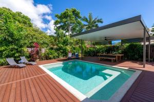 a swimming pool on a deck with a house at Paradiso in Port Douglas