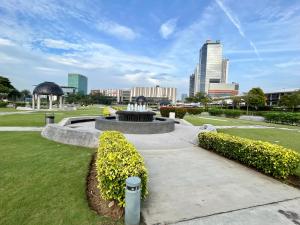 a fountain in a park with a city in the background at 1-5 Pax Comfy Trefoil Studio-Walk to Setia City Mall & Setia City Convention Centre in Shah Alam