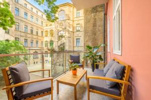 un balcone con sedie, tavolo e un edificio di Best Seasons La Famiglia a Budapest