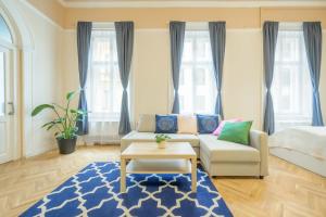 sala de estar con sofá y alfombra azul en Best Seasons La Famiglia en Budapest