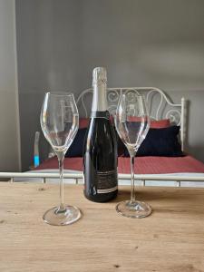 una bottiglia di vino e due bicchieri di vino su un tavolo di Apartma Pekrska vila a Limbuš