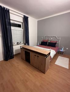 una camera da letto con un letto e un grande tavolo in legno di Apartma Pekrska vila a Limbuš