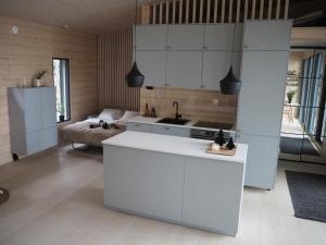 a kitchen with white cabinets and a sink and a bed at Scandinavian lakeside cottage in Rovaniemi