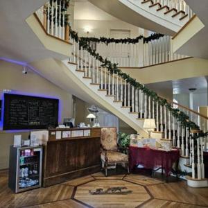 a restaurant with a table and a staircase in a building at The Currier Inn in Greeley