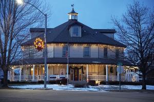 a large house with christmas lights in front of it at The Currier Inn in Greeley