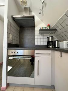 cocina con armarios blancos y fogones en Appartement Bordères-Louron 3 à 5 personnes 3 étoiles, proche Loudenvielle, en Bordères-Louron