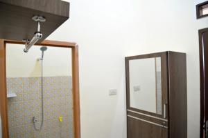 baño con ducha y puerta de cristal en Haura syariah home stay, en Bandar Lampung