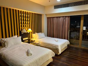 a hotel room with two beds and a window at SunwayLagoonFamilySuite-2pax-Netflix-Balcony-Super Fast Internet in Petaling Jaya
