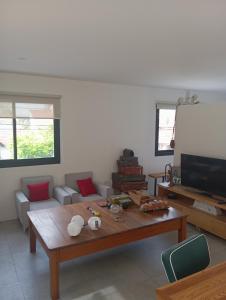 ein Wohnzimmer mit einem Tisch und einem TV in der Unterkunft Loft Mar del Plata in Mar del Plata