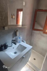 a bathroom with a white sink and a mirror at Mani Tu With Breathtaking View 2 in Éxo Nímfion