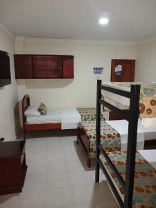 a bedroom with two bunk beds and a tv at hotel paseo colon inn in Barranquilla