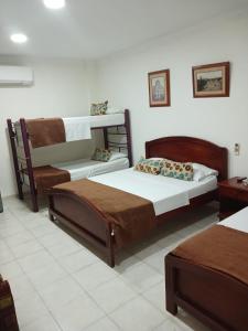 a bedroom with two beds and a bunk bed at hotel paseo colon inn in Barranquilla