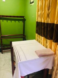 Habitación pequeña con cama y cortina en River Garden Hotel Anuradhapura en Anuradhapura