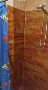 a shower with a wooden floor and a shower curtain at Suite doble Coñaripe in Coñaripe